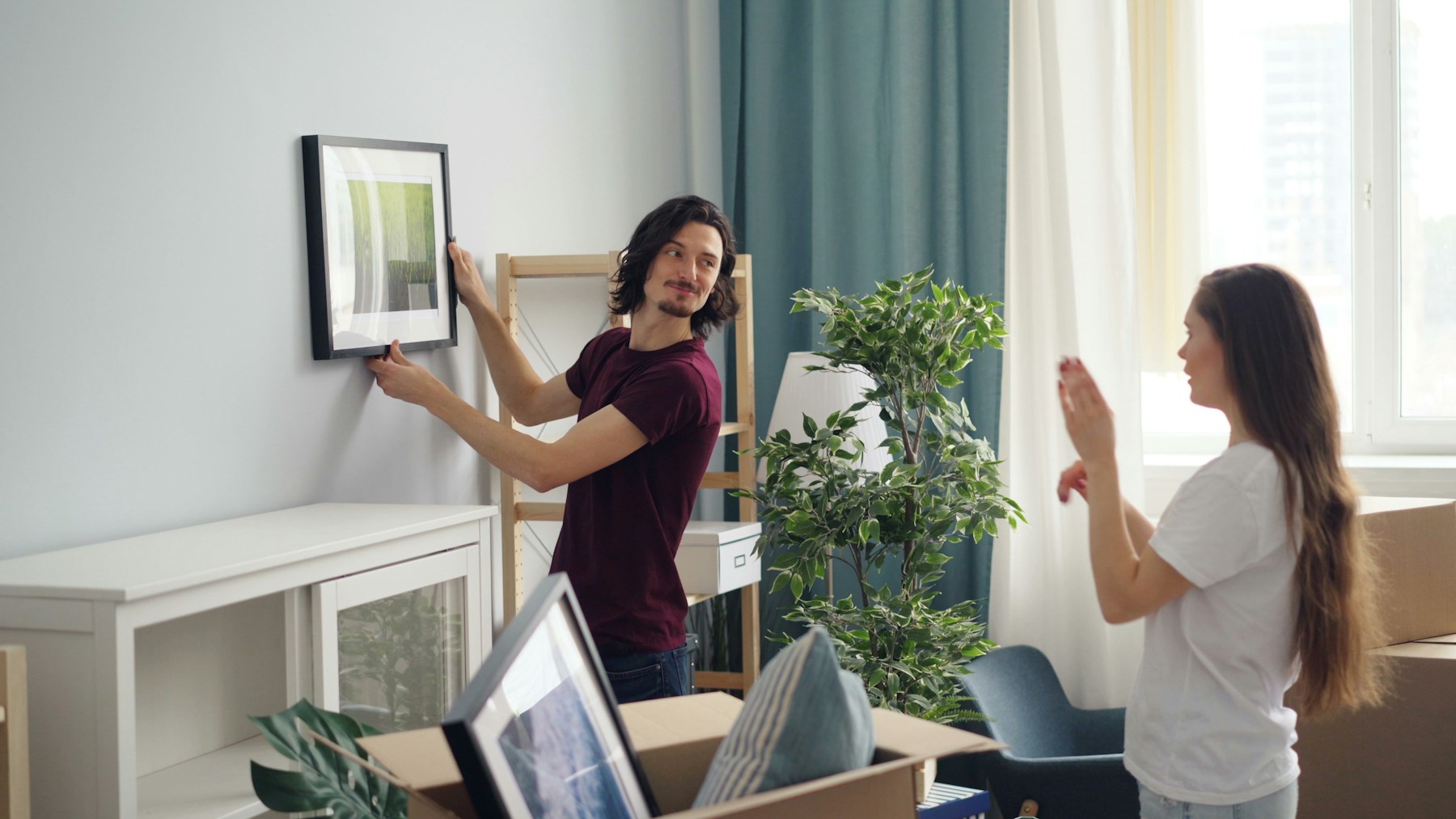 People moving belongings in a bright home